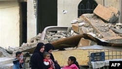An Iraqi family sits outside its destroyed home in Diyala in March 2008