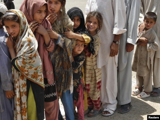 Children stand in line at a distribution center in Kurram.