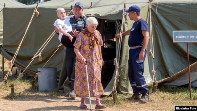 Internally displaced Ukrainians are assisted at a temporary camp for people from Svatovo, in Luhansk region, on August 12.