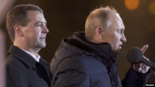 Vladimir Putin addresses supporters as outgoing President Dmitry Medvedev looks on at Manezh Square in Moscow on March 4.