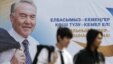 Молодые люди проходят мимо билборда с изображением президента Казахстана Нурсултана Назарбаева. Алматы, 22 февраля 2011 года. 