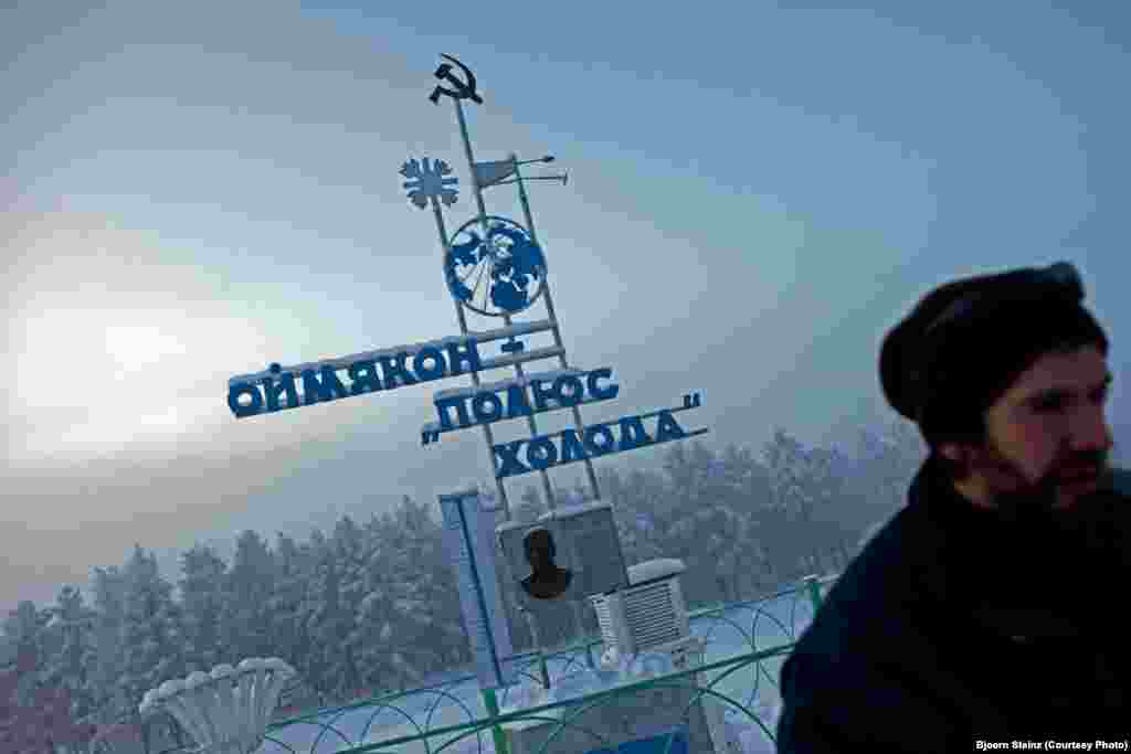 A visitor at "The Pole of Cold" marker in the village of Oymyakon