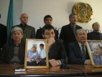 Opposition members with photos of Sarsenbaev at a February news conference (RFE/RL)