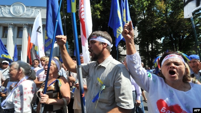 Opposition supporters shout slogans during a protest in front of the Ukrainian parliament in Kyiv on July 30.