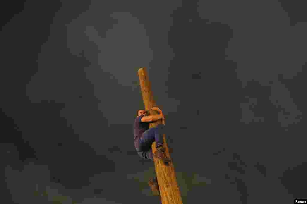 A man climbs up a wooden pole during Maslenitsa celebrations at Gorky Park in Moscow. Maslenitsa is widely viewed as a pagan holiday marking the end of winter and is celebrated with pancake-eating and shows of strength, while the Orthodox Church considers it as the week of feasting before Lent. (Reuters/Maxim Shemetov)