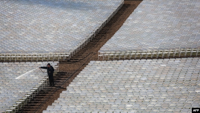 A worker cleans rows of seats where people will watch President Barack Obama take the oath of office during his second inauguration on January 21.
