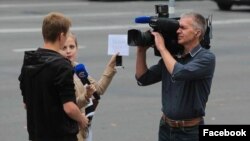 A photo by Uladz Hrydzin shows a reporter and cameraman for Belarus state STV appearing to cue an answer from an interviewee in Minsk.