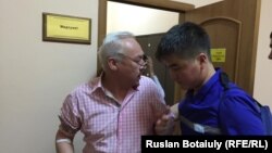 Председатель Союза журналистов Казахстана Сейтказы Матаев (слева) в сопровождении медика в суде. Астана, 23 августа 2016 года.