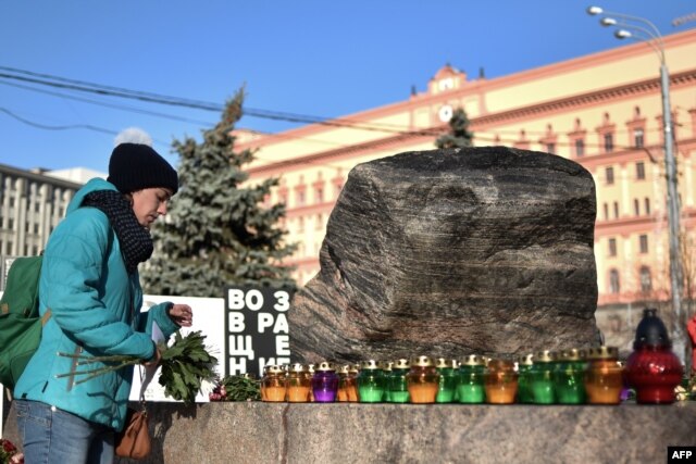 Мәскеудегі сталиндік қуғын-сүргін құрбандары мемориалына шырақ пен гүл қойып жатқан әйел. Жаңа сауалнаманың нәтижесіне қарағанда, ресейліктердің жартысы ондай қуғын-сүргін қазіргі заманда да болуы мүмкін деп есептейді.