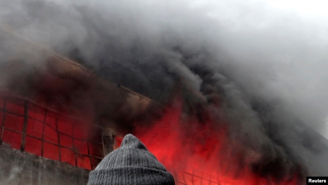 A firefighter attempts to extinguish a fire at a factory after what activists said was shelling by forces loyal to Syria's President Bashar al-Assad in Aleppo on February 8.