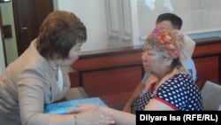 Айыпталушы Қыздығой Ажарқұлова адвокат Гүлнар Жуасбаевамен кеңесіп отыр.