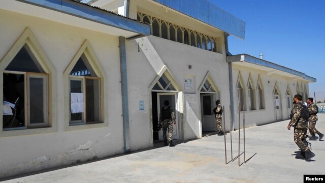 Security forces inspect the entrance to a mosque where Logar Governor Arsala Jamal was killed by a bomb blast on October 15.