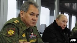 Президент России Владимир Путин (справа) и министр обороны Сергей Шойгу наблюдают за военными учениями. Полигон Кирилловский в Ленинградской области, 3 марта 2014 года.