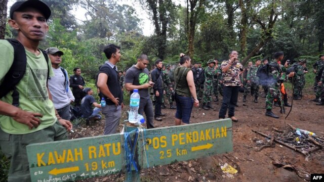 Indonesian soldiers and other members of a search-and-rescue team at the location of the Russian Sukhoi Superjet's crash in Cidahu.