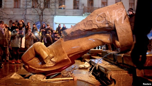 People surround a statue of Soviet state founder Vladimir Lenin that was toppled by protesters during a rally organized by supporters of EU integration in Kyiv on December 8, possibly setting off the rash of Lenin-idolatry abuse.