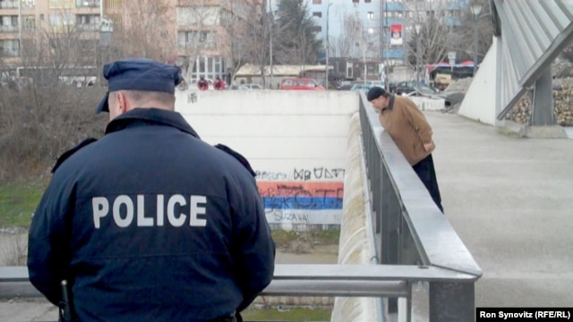 Members of the Kosovo Police Force stand guard on the central bridge in Mitrovica.