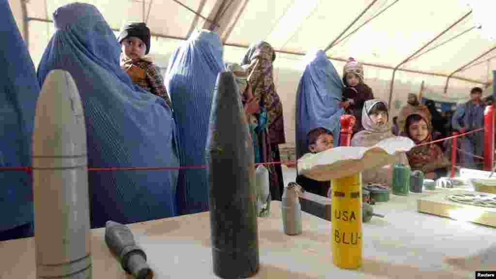 Afghan refugees returning from Pakistan look at explosives and mines during an awareness program at the United Nations High Commissioner for Refugees registration center in Jalalabad Province (Reuters/Parwiz)