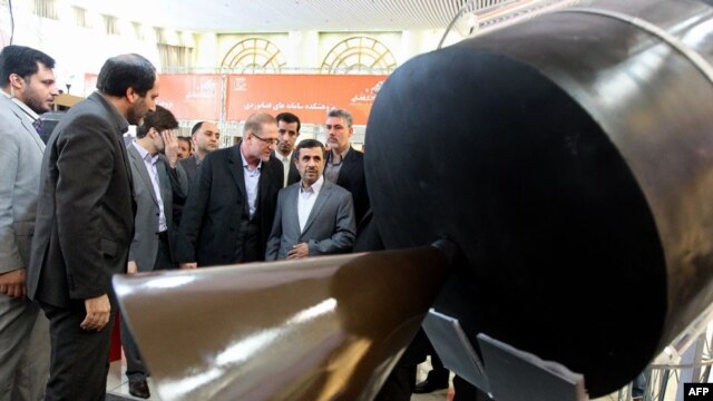 Iranian President Mahmud Ahmadinejad (far right, front) visits an exhibition of space technology during a ceremony to mark Iran's National Day of Space Technology in Tehran on February 4.