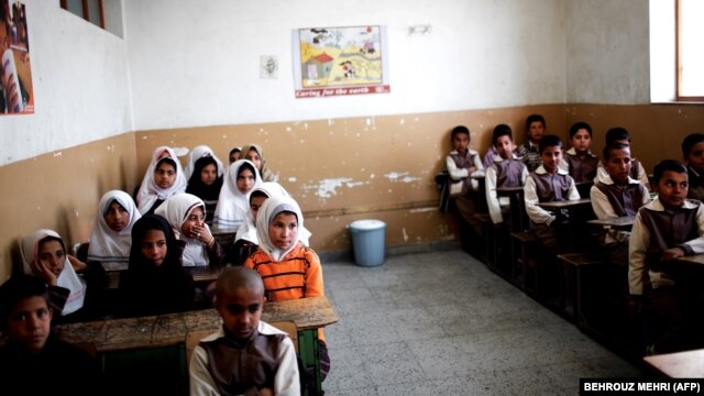 Afghan schoolchildren attend a class at the Shahid Nasseri refugee camp in the village of Taraz Nahid near the city of Saveh, some 130 kilometers southwest of the Iranian capital, Tehran, in February 2015.