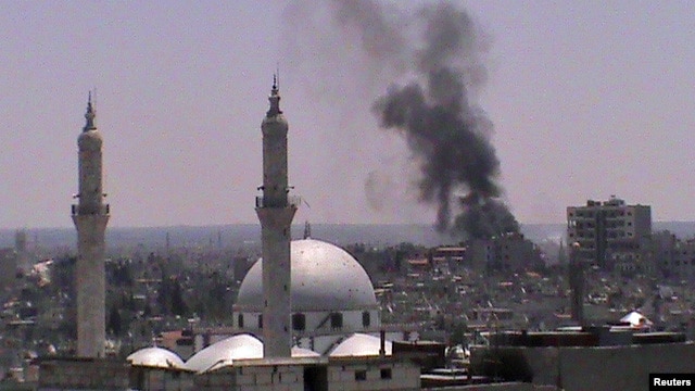 Smoke rises from the Juret al-Shayah district in the Syrian city of Homs on July 11.