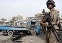 An Iraqi soldier stands guard near a damaged civilian truck at the site of a roadside bomb explosion in Al-Saadon street in Baghdad, April 17 (epa)