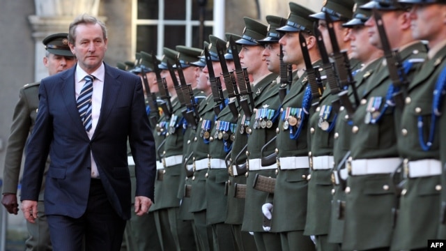 Premierul irlandez Enda Kenndy inspectînd garda de onoare la o ceremonie de înălțare a drapelului la Castelul din Dublin la 31 decembrie 2012