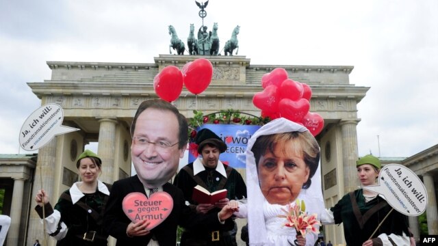 NGO aktivisti sa maskama Angele Merkel i Francoisa Hollanda, Berlin, maj 2012.