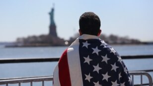 An immigrant looks toward New York's Statue of Liberty during a march for immigration reform in April.