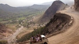 PAKISTAN - Passengers ride along a mountainside road in Pakistan's North West Frontier Province.