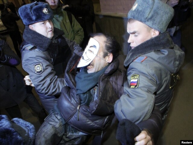 Russian police officers detain an activist during a copycat Occupy protest in central Moscow on November 7.