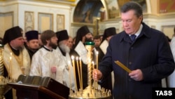 As the streets of Kyiv are convulsed with unrest, Ukrainian President Viktor Yanukovych (right) places a candle to mark the country's Day of Unity on January 22.