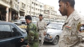 Disarmed members of the Sunni militia man a checkpoint in Baghdad.