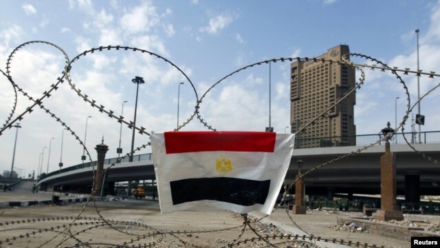 An Egyptian flag is hung on barbed wire by opposition supporters on the front line near Tahrir Square in Cairo 