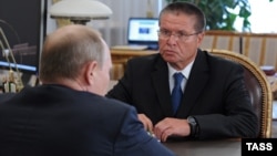 Russian President Vladimir Putin (foreground) speaks with Economy Minister Aleksei Ulyukayev. (file photo)