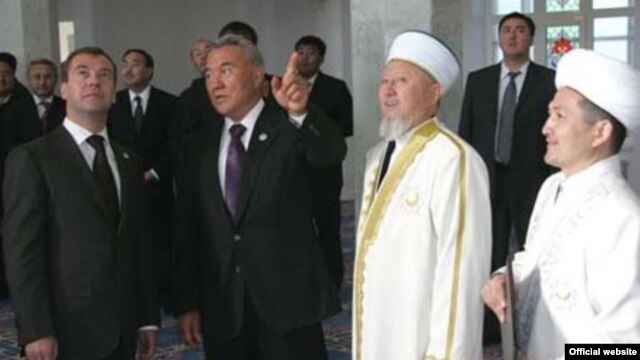 Бауыржан Есмахан Ақтөбенің бұрынғы бас имамы кезінде (оң жақ шетте) "Нұрғасыр" мешітінің ашылу салтанатына келген лауазымды қонақтармен бірге. Сурет Қазақстан мұсылмандары діни басқармасының сайтынан алынды.