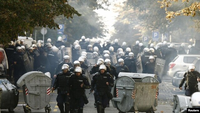 Riot police run down a street during clashes in Belgrade with antigay protesters on October 10.