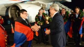 Armenia - President Serzh Sarkisian (R) greets members of the Armenian men's chess team at Yerevan's Zvartnots airport, 10Sept2012.