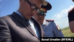 Сотрудник департамента КНБ и полицейский проверяют списки журналистов во время визита премьер-министра Карима Масимова в Западно-Казахстанскую область. Уральск, 11 августа 2016 года.
