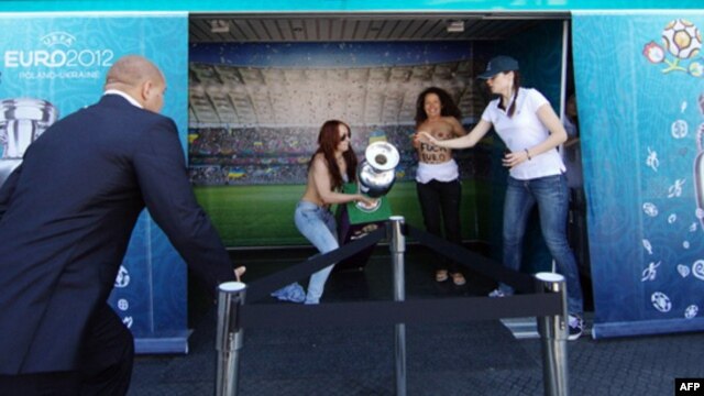 Femen activists make their move with the Euro 2012 trophy on display in the Ukrainian city of Dnipropetrovsk on May 21.