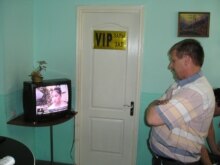 Kazakhstan -- Man watches TV news in Almaty hair salon, 23Jun2006