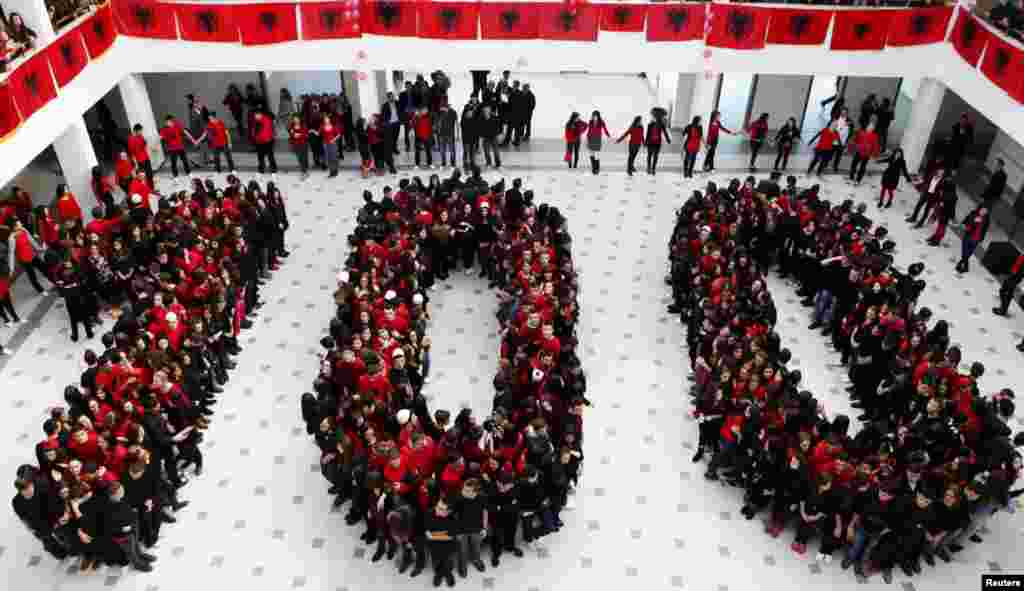 Pupils from the Xhevdet Doda secondary school in Pristina, the capital of Kosovo, form the number 100 in the colors of the Albanian flag.