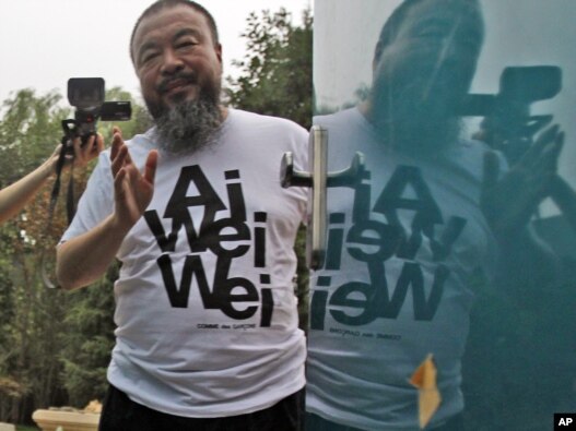 Activist artist Ai Weiwei speaks to journalists gathered outside his home in Beijing in June, after nearly three months of detention.