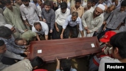 Relatives and colleagues carry the casket of Pakistani journalist Salim Shahzad for burial in Karachi in June 2011.