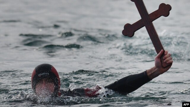 A Romanian diver shows a wooden cross he retrieved from the Black Sea during an Epiphany religious service in Constanta.