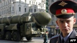 A Russian policeman stands in front of a Topol-M ICBM during a rehearsal for the Victory Day parade in Moscow in May 2008.