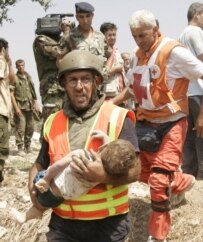 A Red Cross rescuer carries the body of child killed in the July 30 Israeli air strike in Qana (epa)