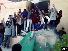 Anti-government demonstrators destroying a monument to leader Muammar Qadhafi's Green book