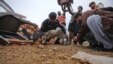 A policeman, rescue workers, and security officials collect evidence from the site of a bomb attack in western Pakistan in January.
