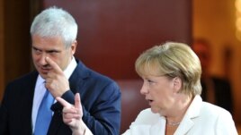 Serbian President Boris Tadic and German Chancellor Angela Merkel arrive at a joint news conference after their meeting in Belgrade.