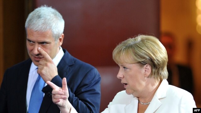 Serbian President Boris Tadic and German Chancellor Angela Merkel arrive at a joint news conference after their meeting in Belgrade.